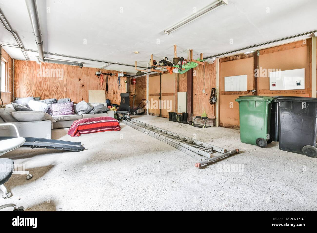 Bidoni spazzatura e mobili vari posti all'interno di ampio garage con muri  di legno in casa Foto stock - Alamy