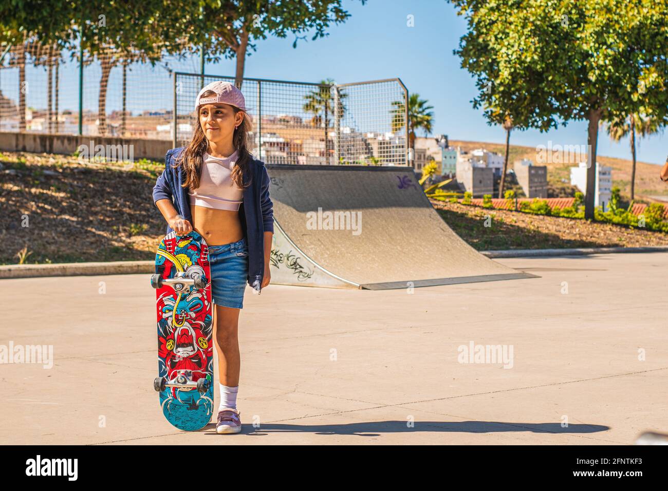 Ritratto di una ragazza caucasica skater con il suo skateboard dentro un parco per skate Foto Stock