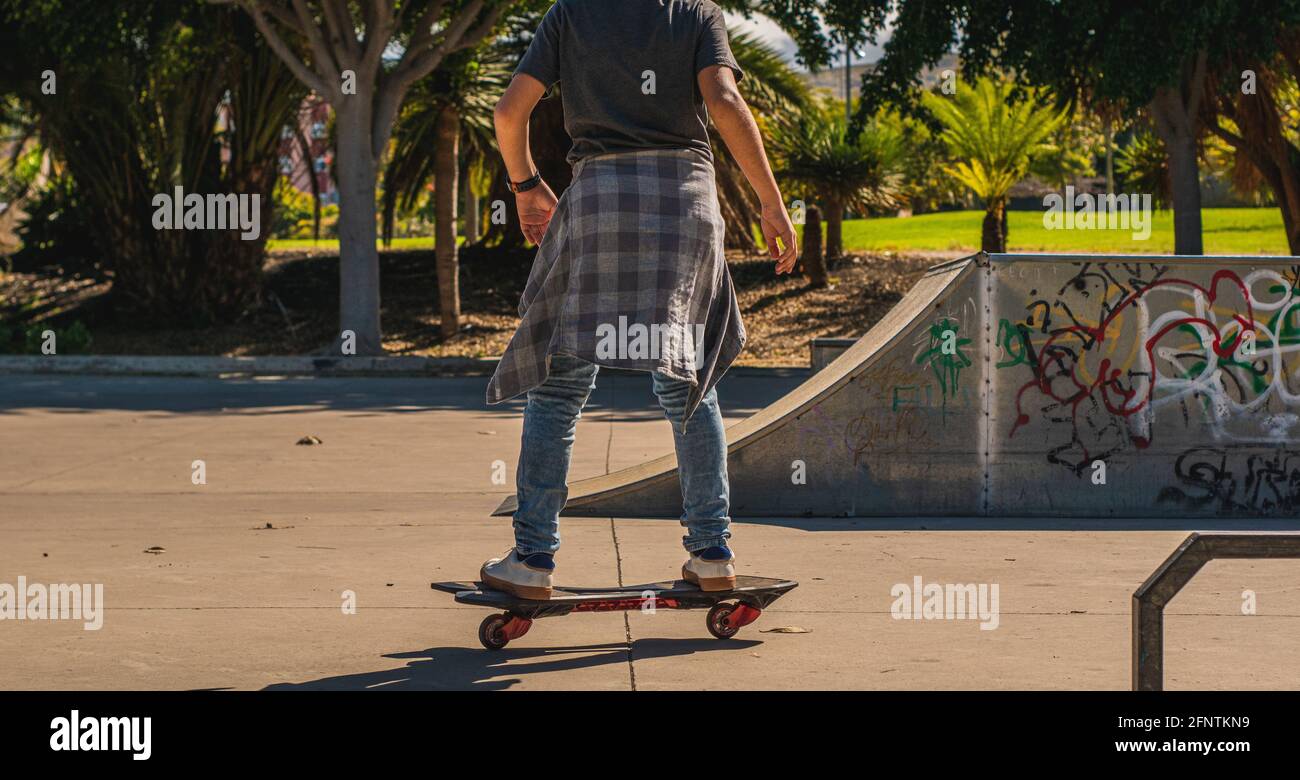 Ragazzo irriconoscibile che pattina con il suo skateboard in un parco di skate Foto Stock