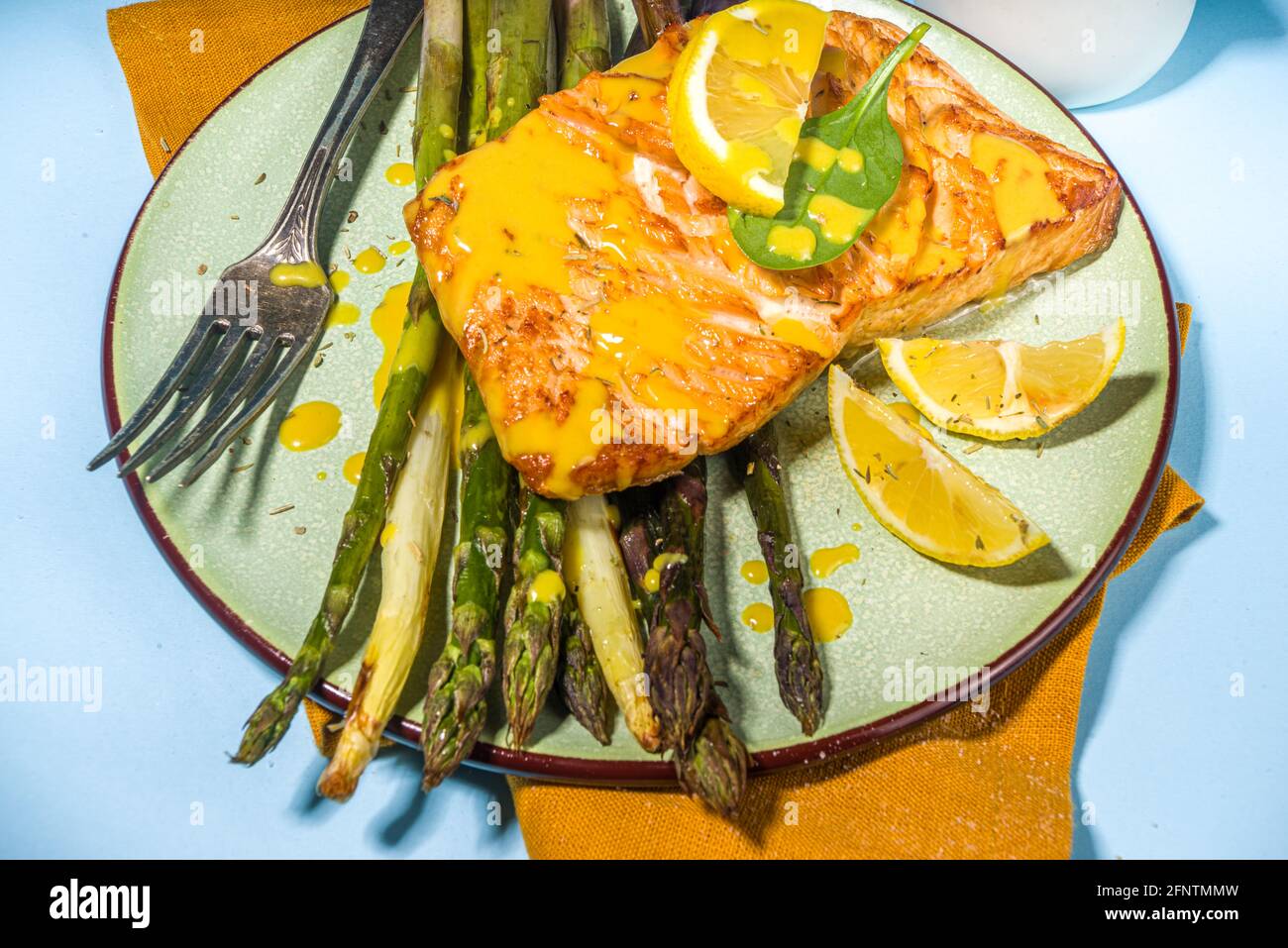 Cibo vegano sano, ricetta dieta keto, bistecca di pesce salmone alla griglia al forno con asparagi verdi, bianchi, viola, azzurro sole illuminato sfondo vista dall'alto Foto Stock