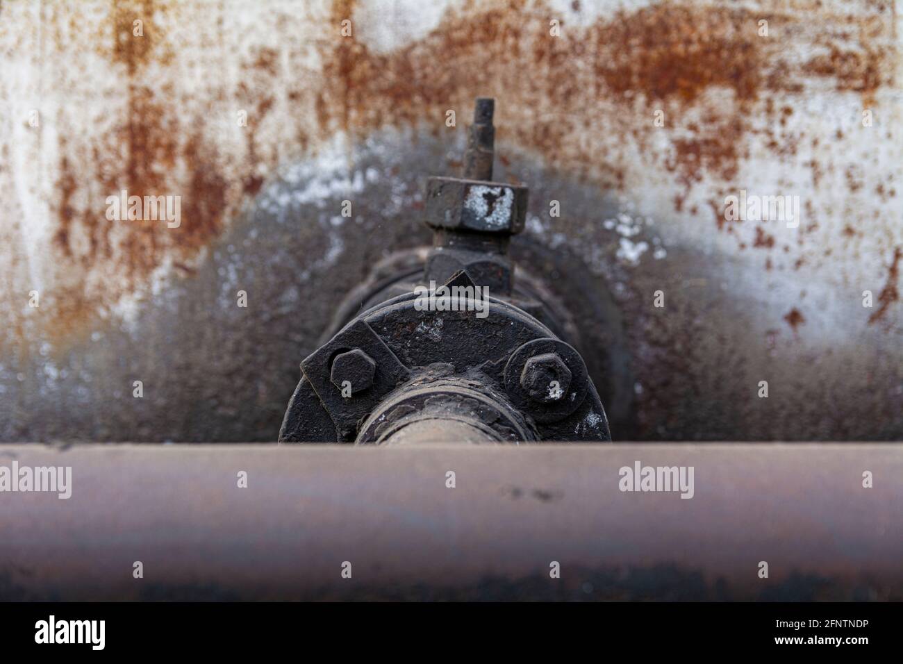 Tubo per gasolio o olio con valvola. Uno strato di combustibile nero essiccato su un vecchio rubinetto metallico. Foto Stock