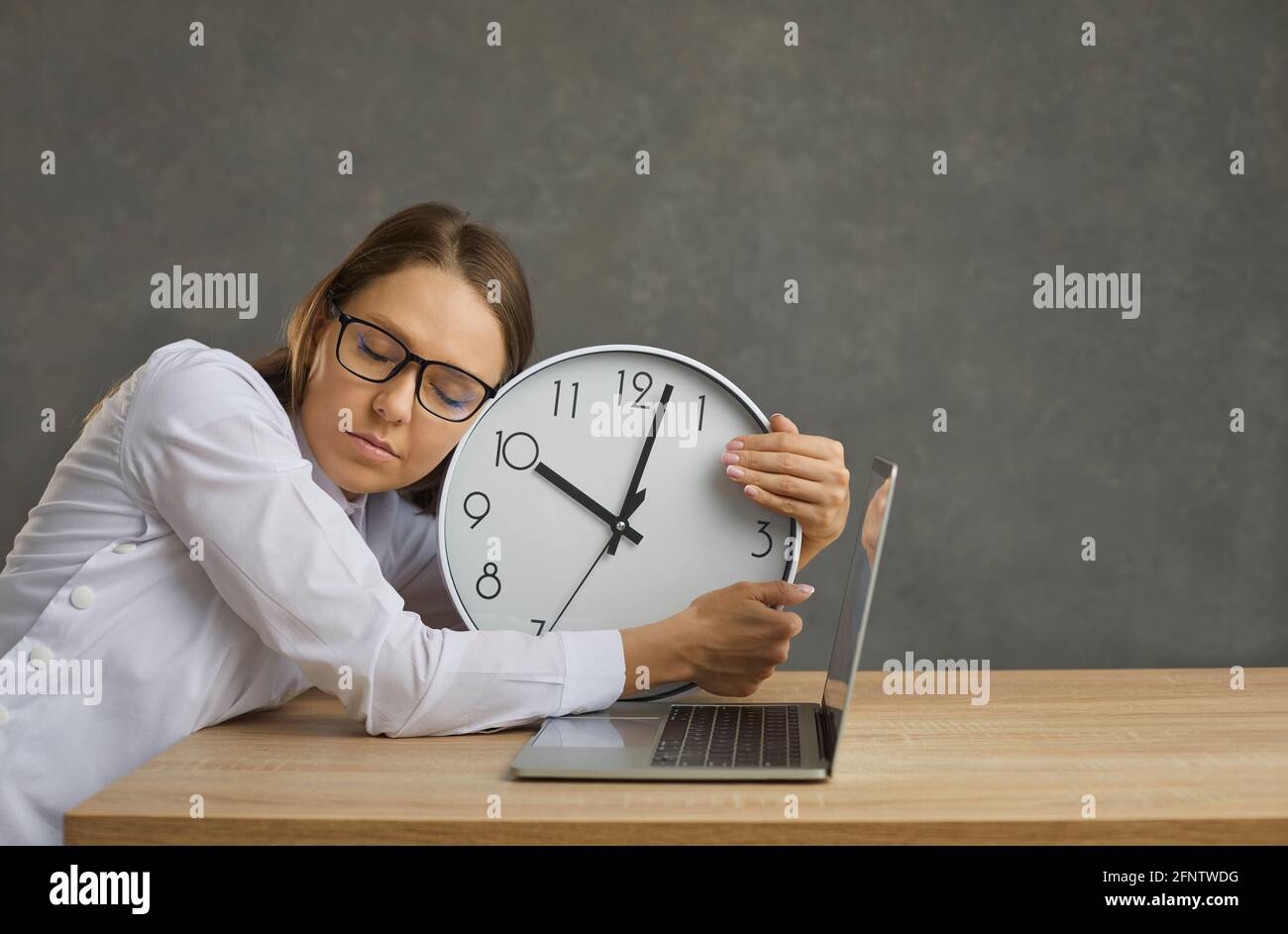 Il freelance del personale dormiva al lavoro e si è occupato di un orario di lavoro alla reception di computer portatile Foto Stock