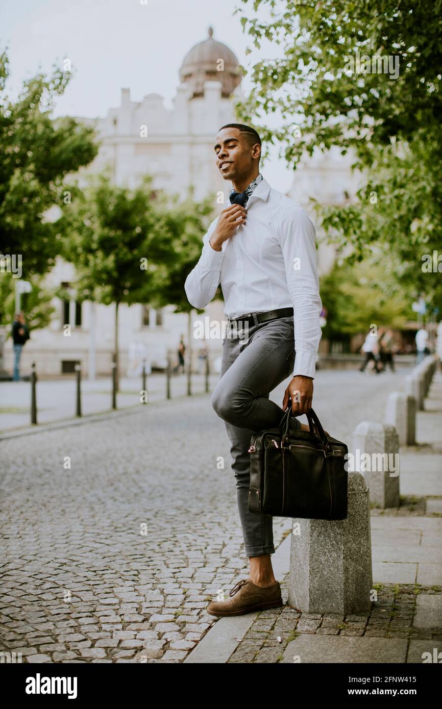 Bell'uomo d'affari afro-americano che ha in attesa di un taxi su un via Foto Stock