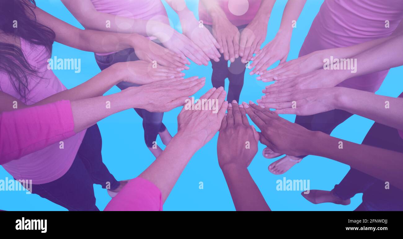 Composizione di amici femminili che toccano le mani in cerchio su blu sfondo Foto Stock