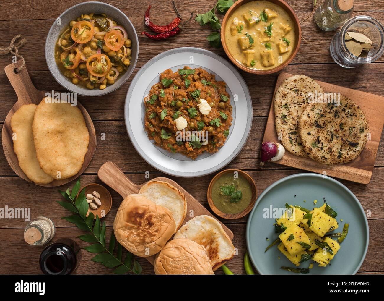 Flatlay di cibo indiano: punjabi chole, pav bhaji, shahi paneer, e dhokla Foto Stock