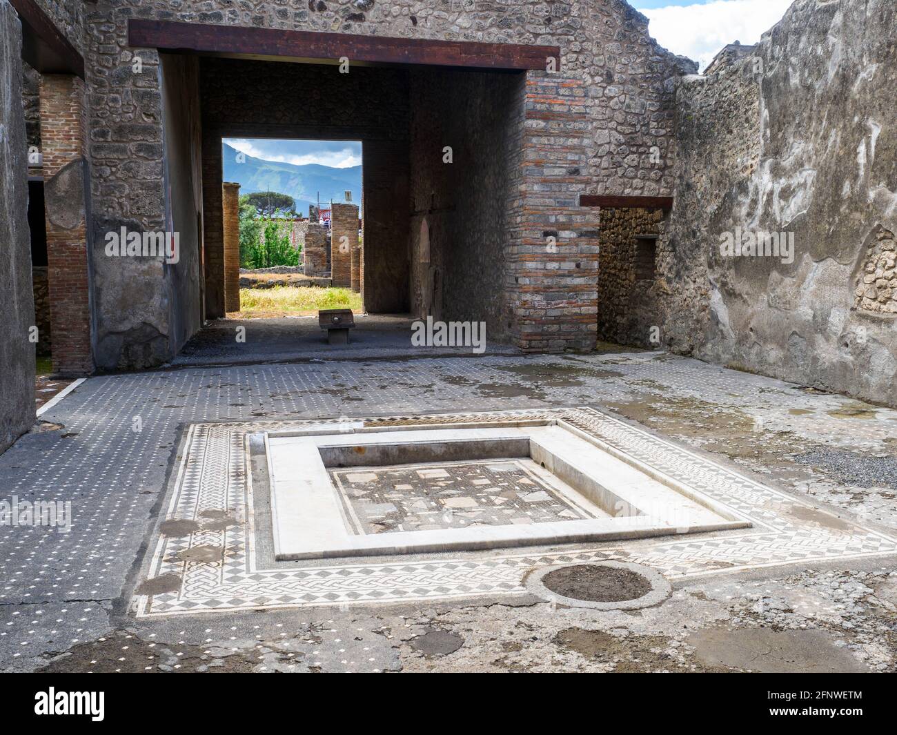 Atrio quadrato con impianto centrale. Il pavimento dell'atrio è costituito da lava frantumata decorata con piccoli trucioli di marmo bianco. Casa del frutteto - Sito archeologico di Pompei, Italia Foto Stock