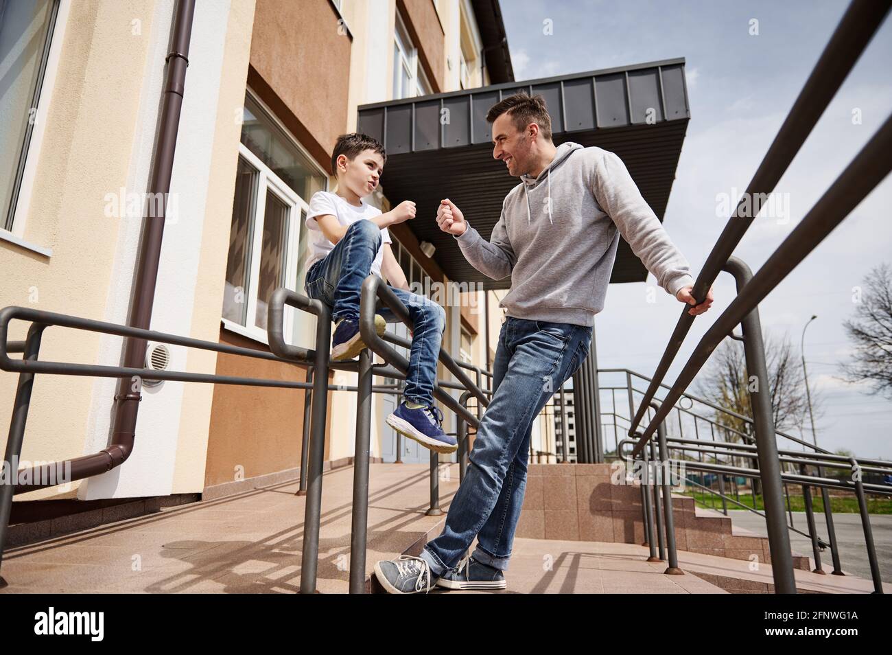 Ritratto a tutta lunghezza di un padre felice che gioca un gioco di rock-paper-forbici con suo figlio. Concetto di Giornata dei padri, protezione Internazionale dei Bambini da Foto Stock