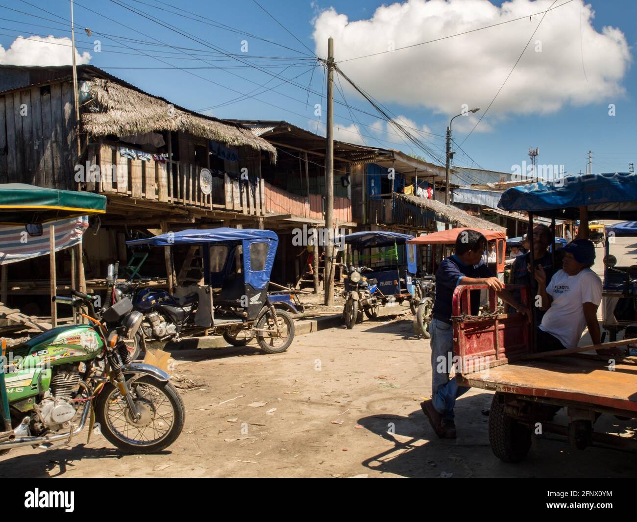 Iquitos, Perù - 15 maggio 2016: Risciò colorati e enormi sacchi di carbone su un bazar nel distretto di Belén di Iquitos, il distretto più povero di Iquitos, per Foto Stock