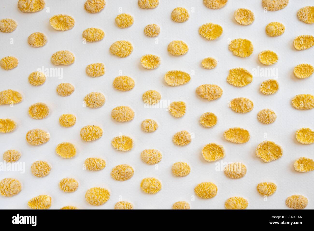 fiocchi di mais isolati su sfondo bianco, ingredienti alimentari, cereali di mais gialli per colazione, mucchio di fiocchi di mais zuccherati, scaglie di mais patt Foto Stock