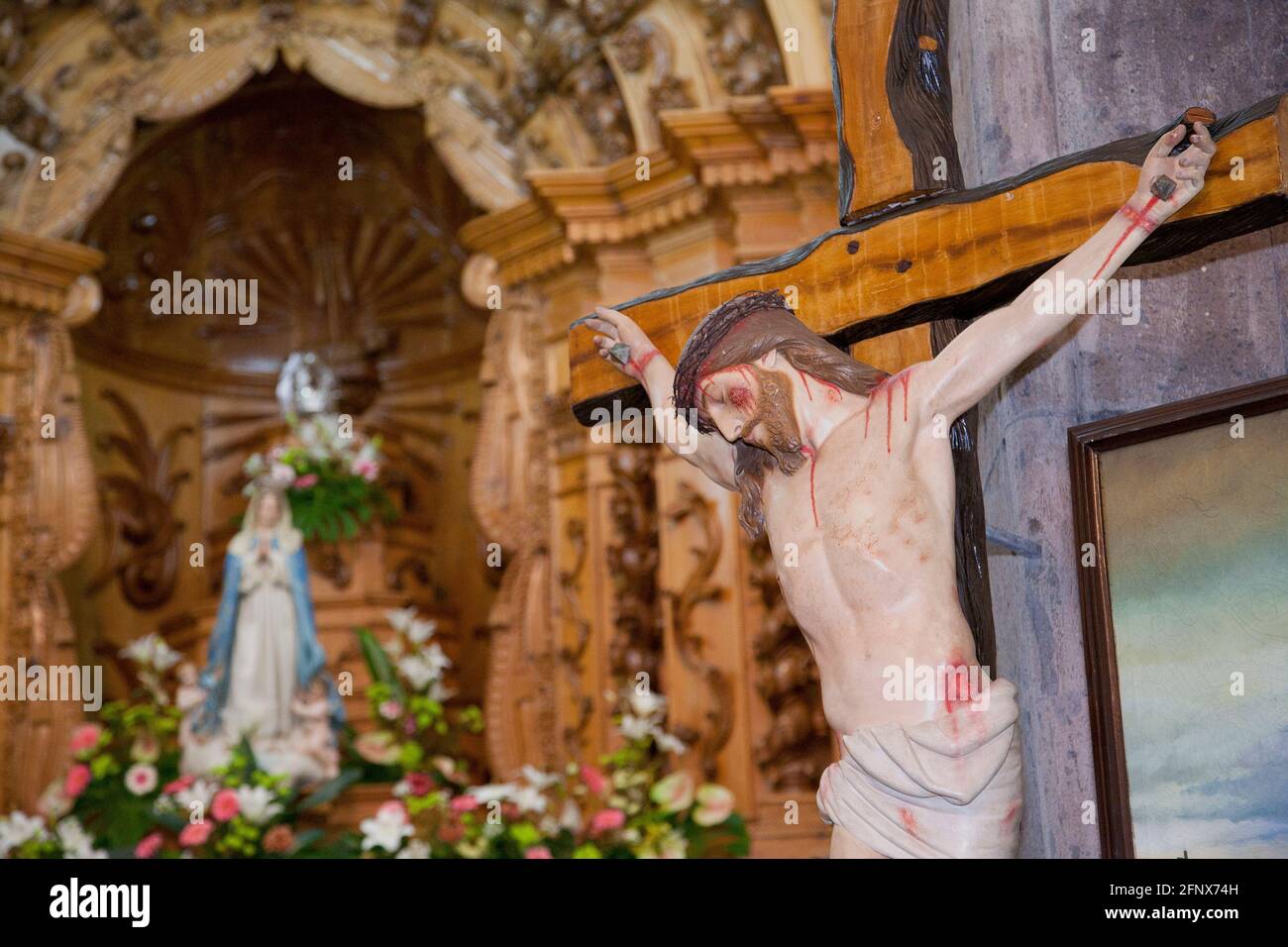 Immagine di Gesù Cristo crocifisso, con immagine della Vergine Maria sullo sfondo. Chiesa dello Spirito Santo, Vila Franca do campo, Azzorre, Portogallo Foto Stock