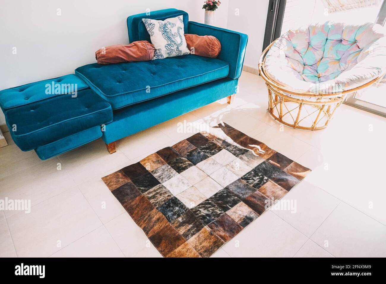 Un soggiorno decorato con un divano in velluto verde e. un tappeto di  cowhide Foto stock - Alamy