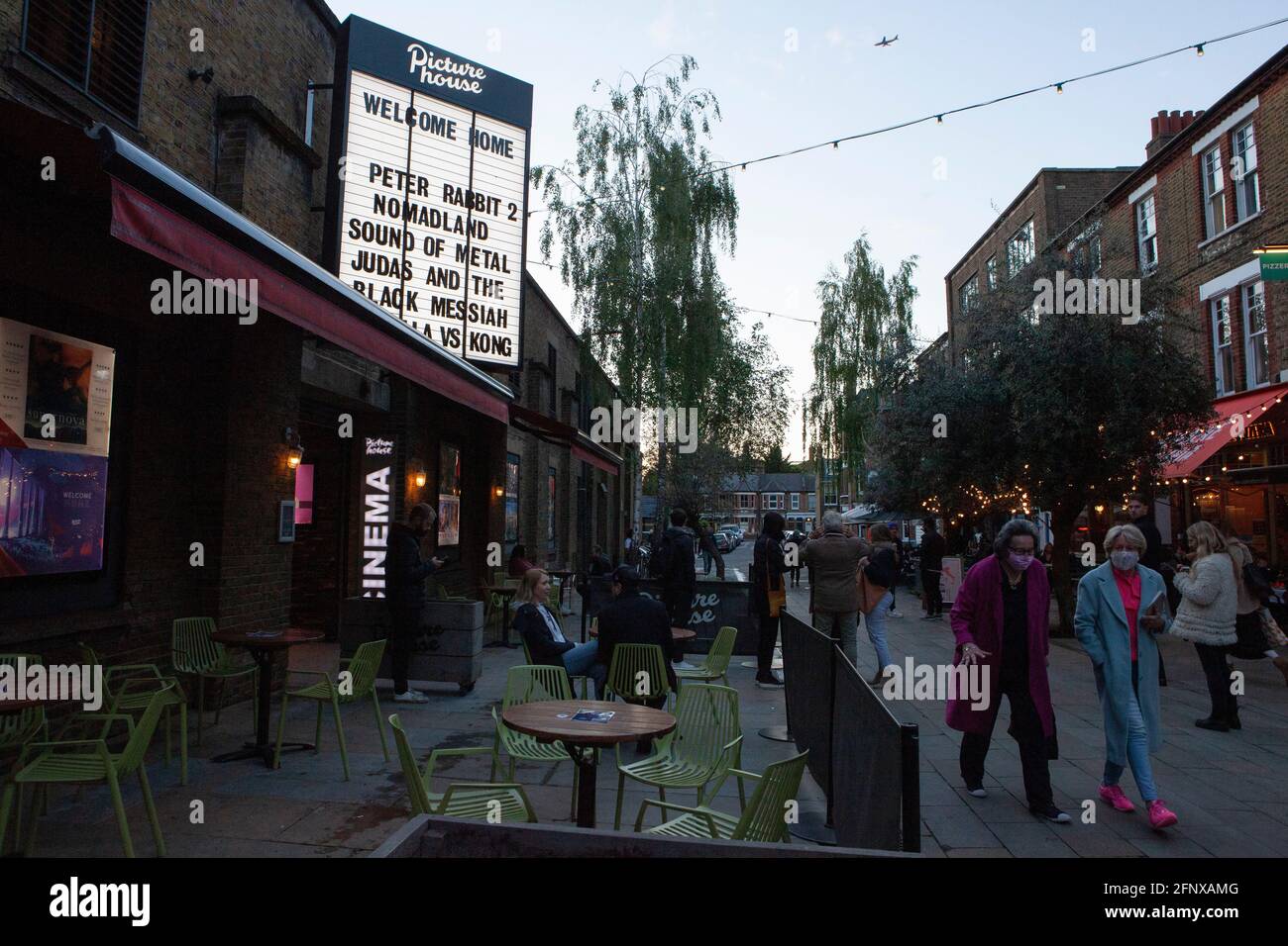 Clapham, Londra, 19 maggio 2021: Il pubblico lascia il cinema Clapham Picturehouse dopo il primo giorno di apertura, in quanto è stato chiuso in ottobre a causa della pandemia del coronavirus. Molti film sono stati ritardati di mesi o anche oltre un anno. Le attività ricreative al coperto sono consentite solo dall'inizio di questa settimana. I clienti devono indossare maschere facciali e le schermature sono sedute a metà della loro capacità abituale. Anna Watson/Alamy Live News Foto Stock