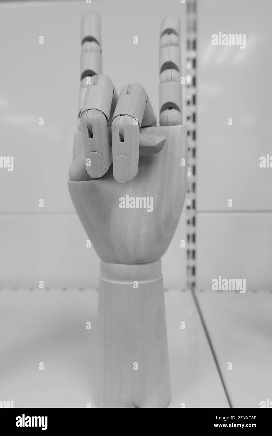 La mano di legno mostra il segno della roccia dura. Sottocultura. Foto Stock