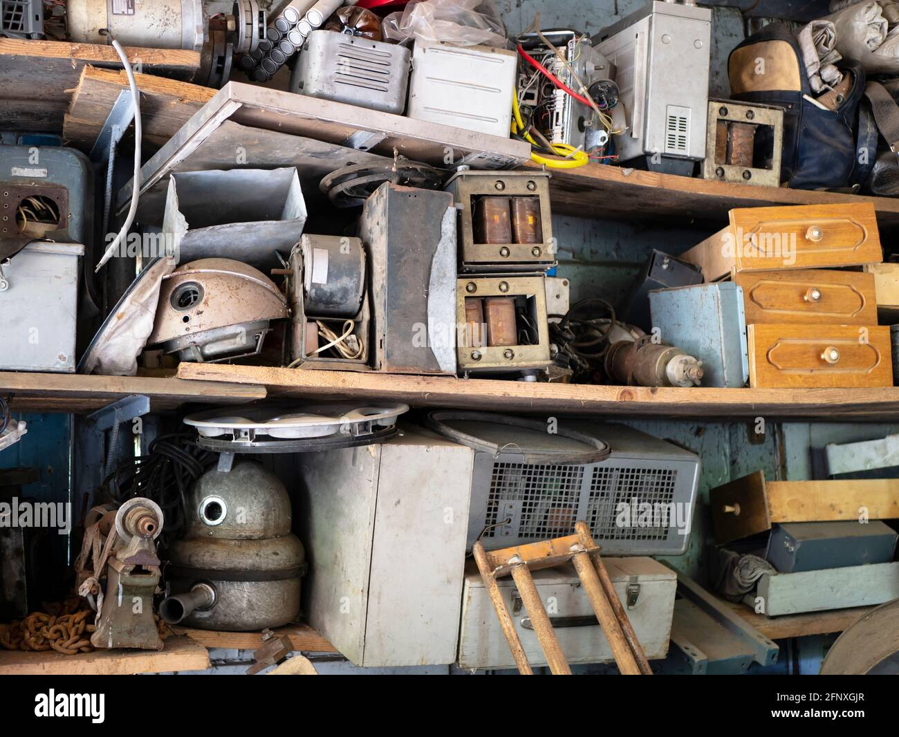 Scaffali completi di attrezzature vintage e cose in garage abbandonato, ammasso, cose inutili Foto Stock