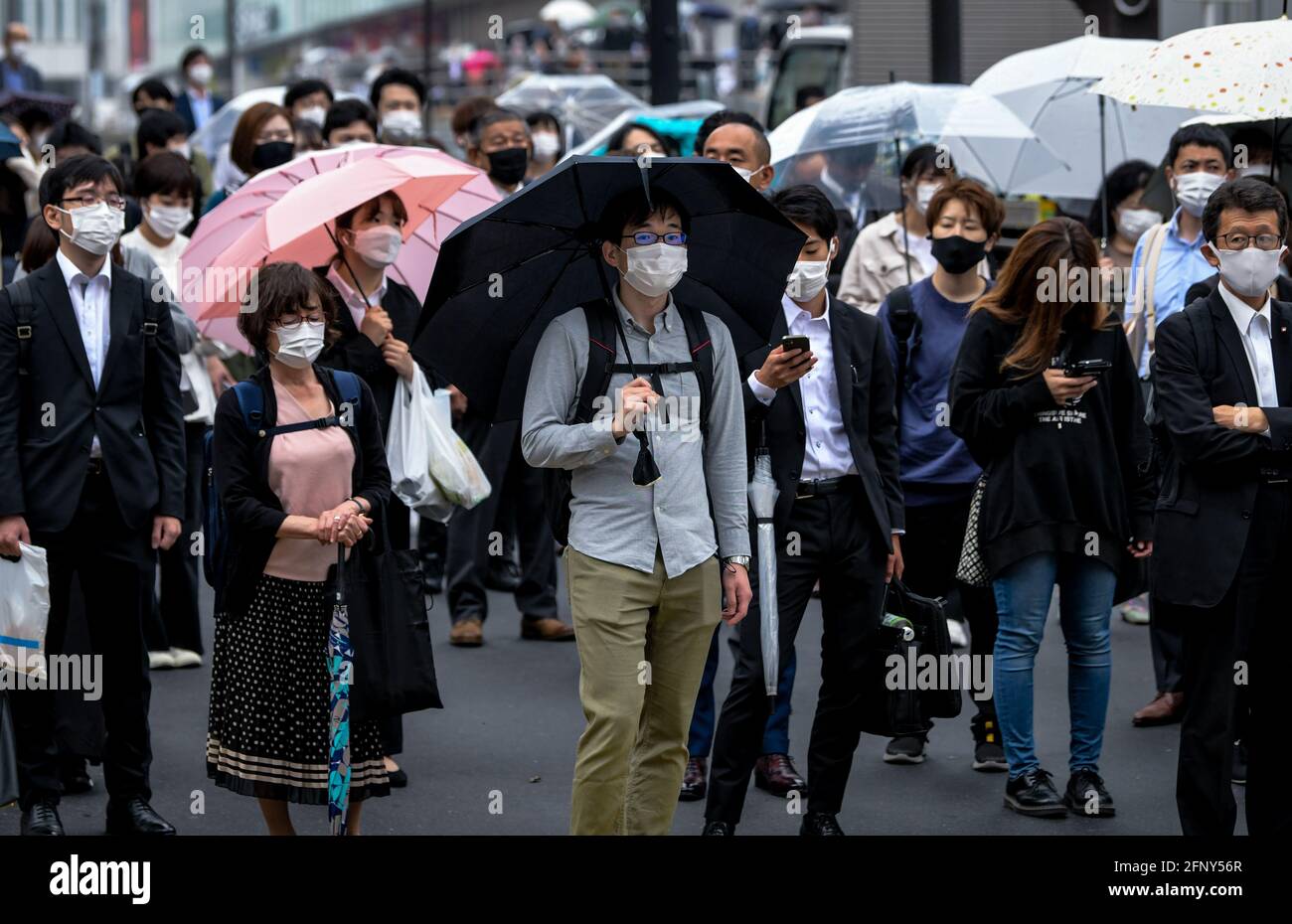 Tokyo, Giappone. 19 maggio 2021. Le persone che indossano maschere per la protezione contro la diffusione di Covid-19 camminano lungo una strada trafficata nella zona di Shinjuku di Tokyo. Credit: SOPA Images Limited/Alamy Live News Foto Stock
