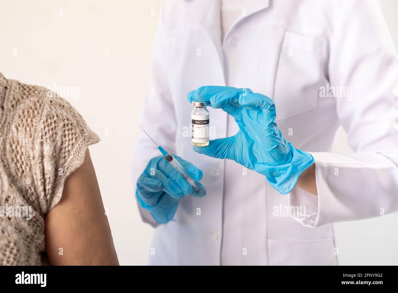 Il medico prepara una siringa con il vaccino del coronavirus per un paziente. Foto Stock