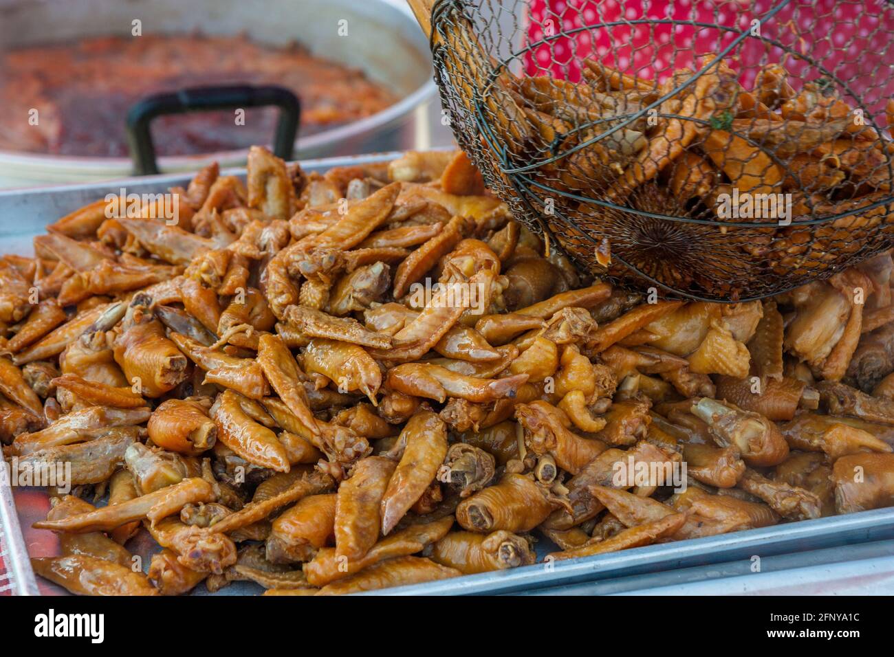Ali di pollo appena stufate nel mercato locale di strada della Laotia Foto Stock