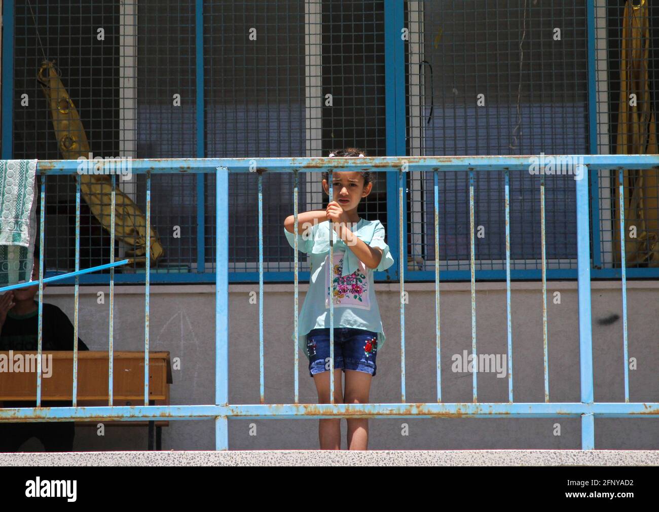 Gaza. 19 maggio 2021. La ragazza palestinese Lamis al-Sultan si pone per una foto in una scuola a Gaza, il 19 maggio 2021. Al-Sultan, 7 anni, che è fuggito dalla sua casa dopo che è stato danneggiato durante gli attacchi aerei israeliani, si rifugiò nella scuola come molti altri palestinesi. Credit: Rizek Abdeljawad/Xinhua/Alamy Live News Foto Stock