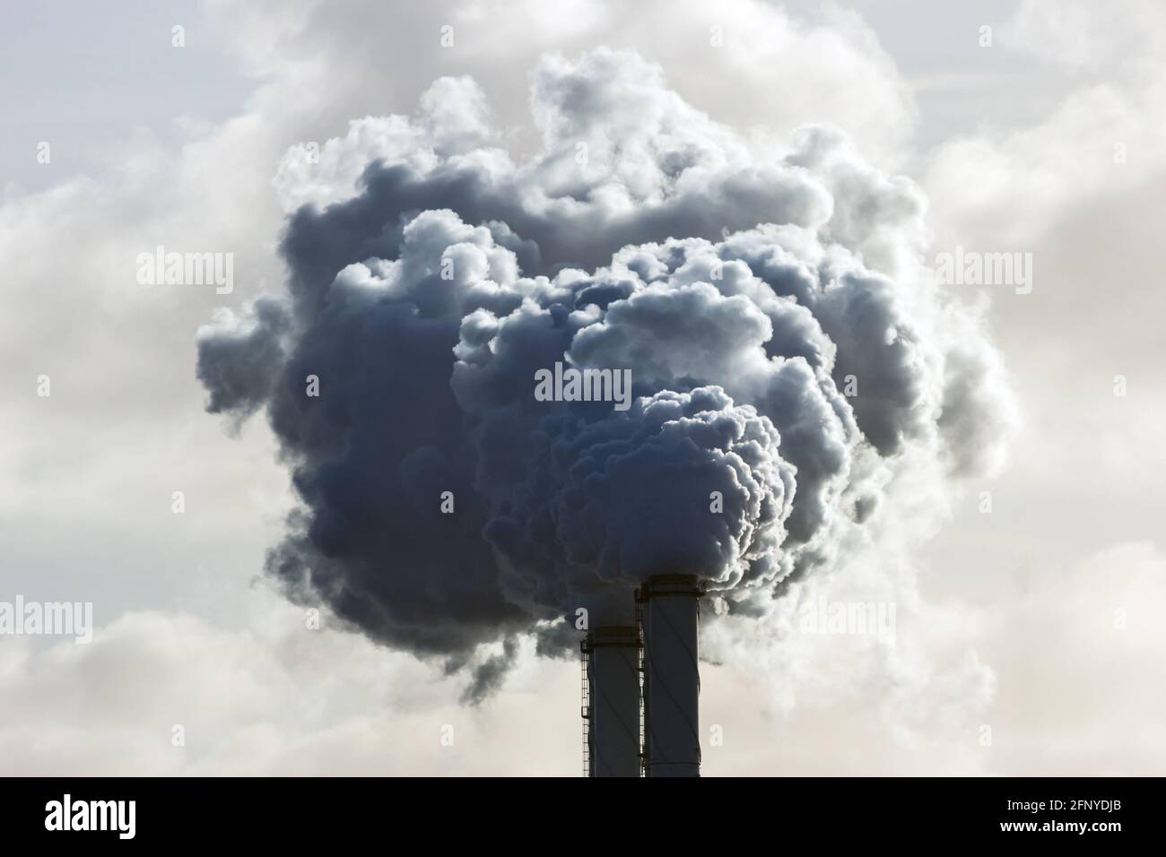 Tubi del camino di fumo di una centrale elettrica che causa inquinamento atmosferico. Foto Stock