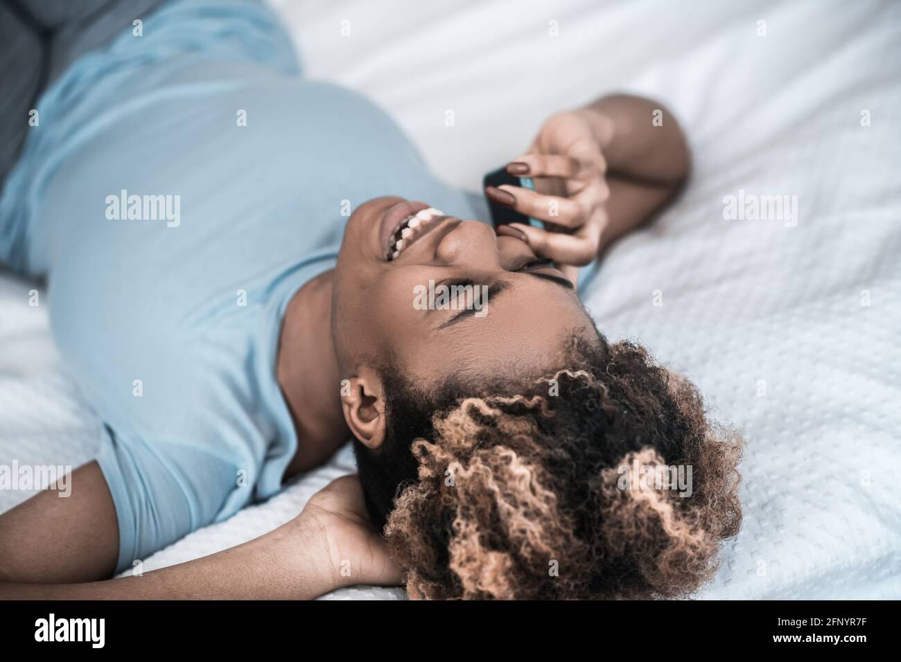 Giovane donna adulta che si diverte a chiacchierare con lo smartphone Foto Stock