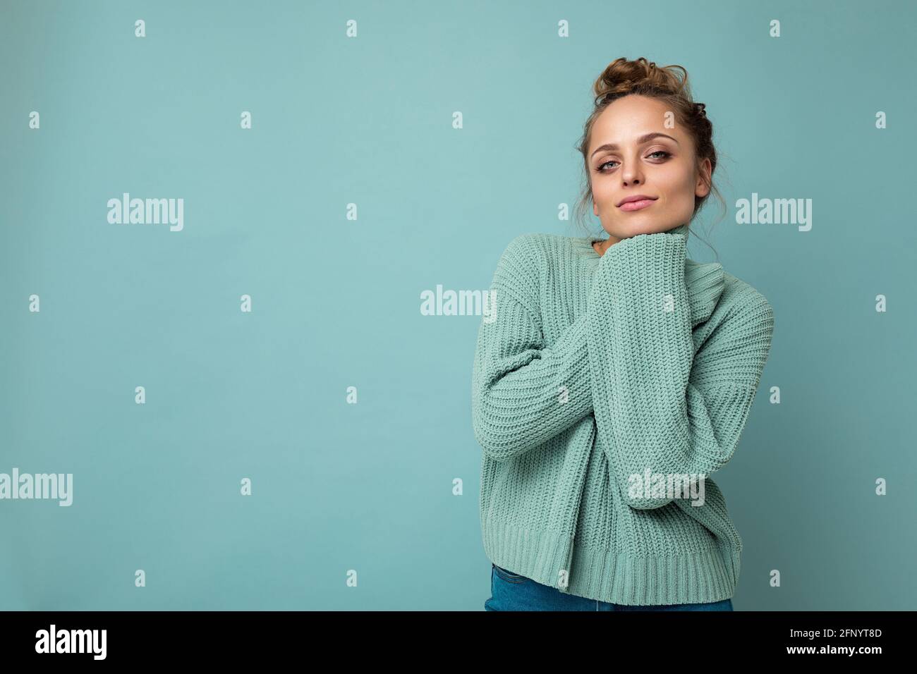 Ritratto di giovane felice positivo soddisfatto carino accogliente bello donna bionda con emozioni sincere indossando casual pullover blu isolato acceso Foto Stock