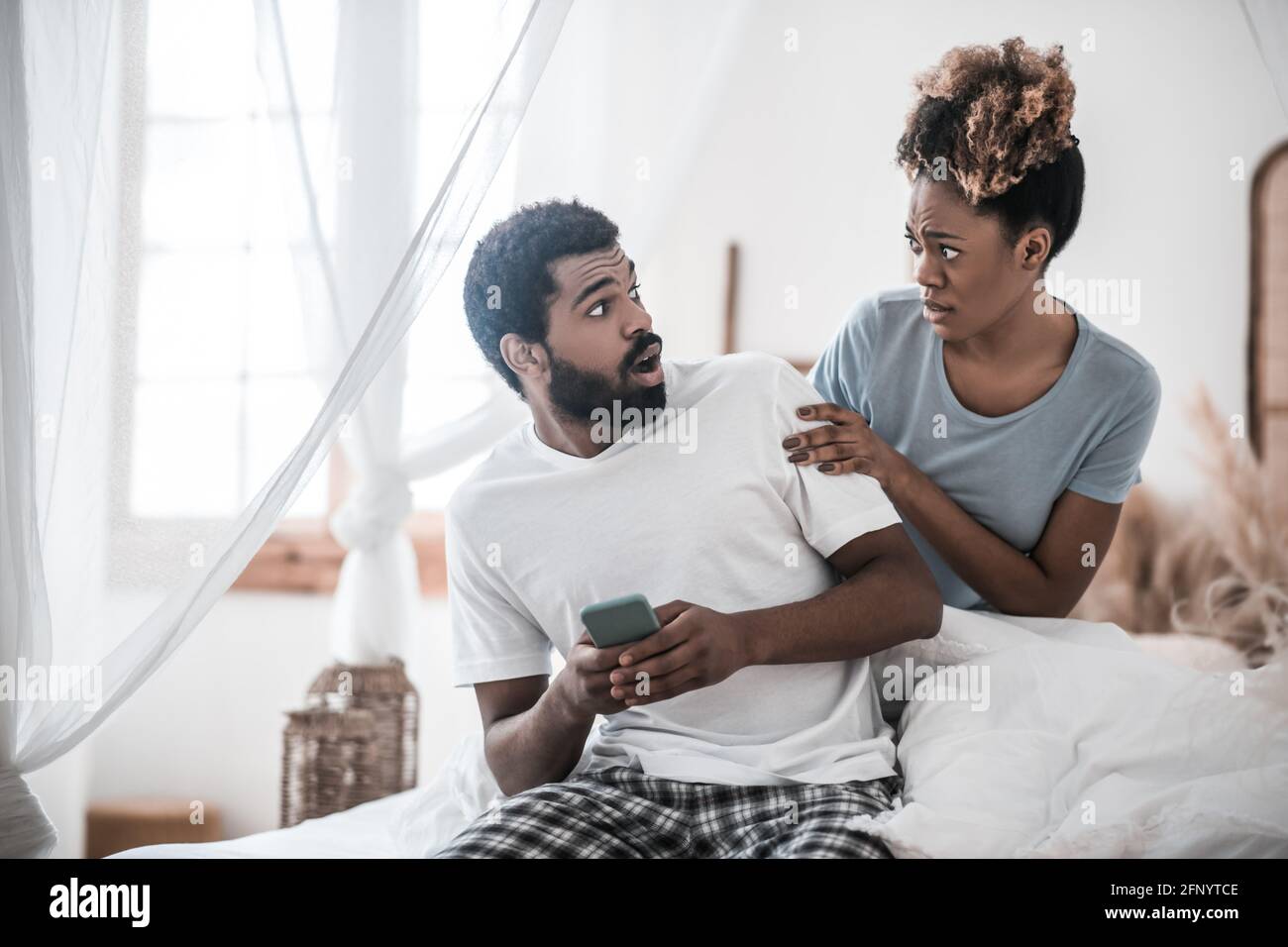 Uomo e donna sorpresi che si guardano l'un l'altro Foto Stock