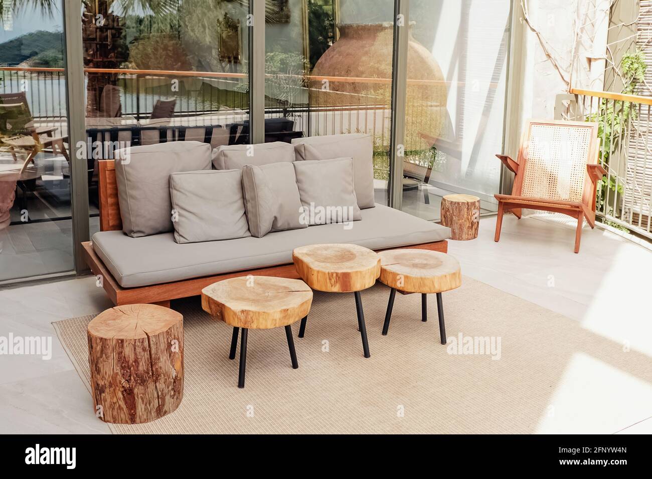 Divano in legno e tavolini da caffè su un'elegante e moderna terrazza Foto Stock