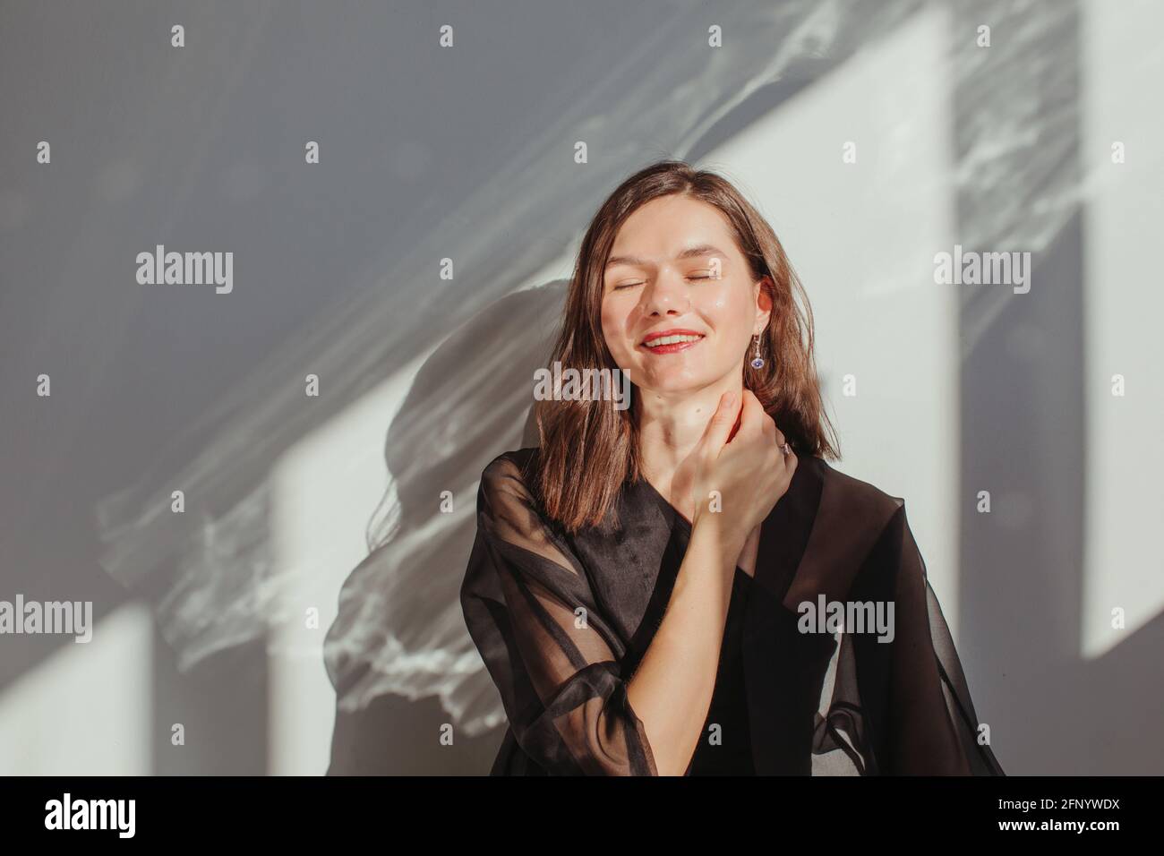 Ritratto di una bella donna felice con la mano sopra il collo Foto Stock