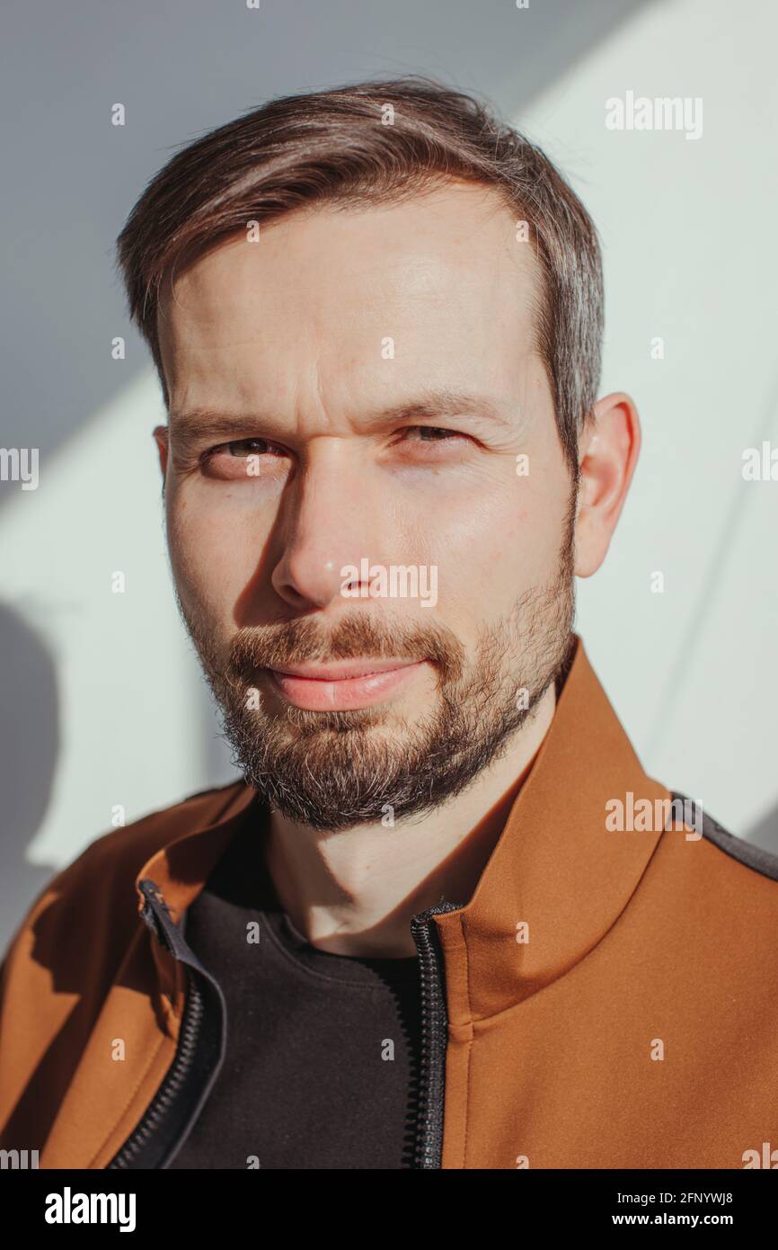 Ritratto di un bell'uomo con una barba in piedi luce solare Foto Stock