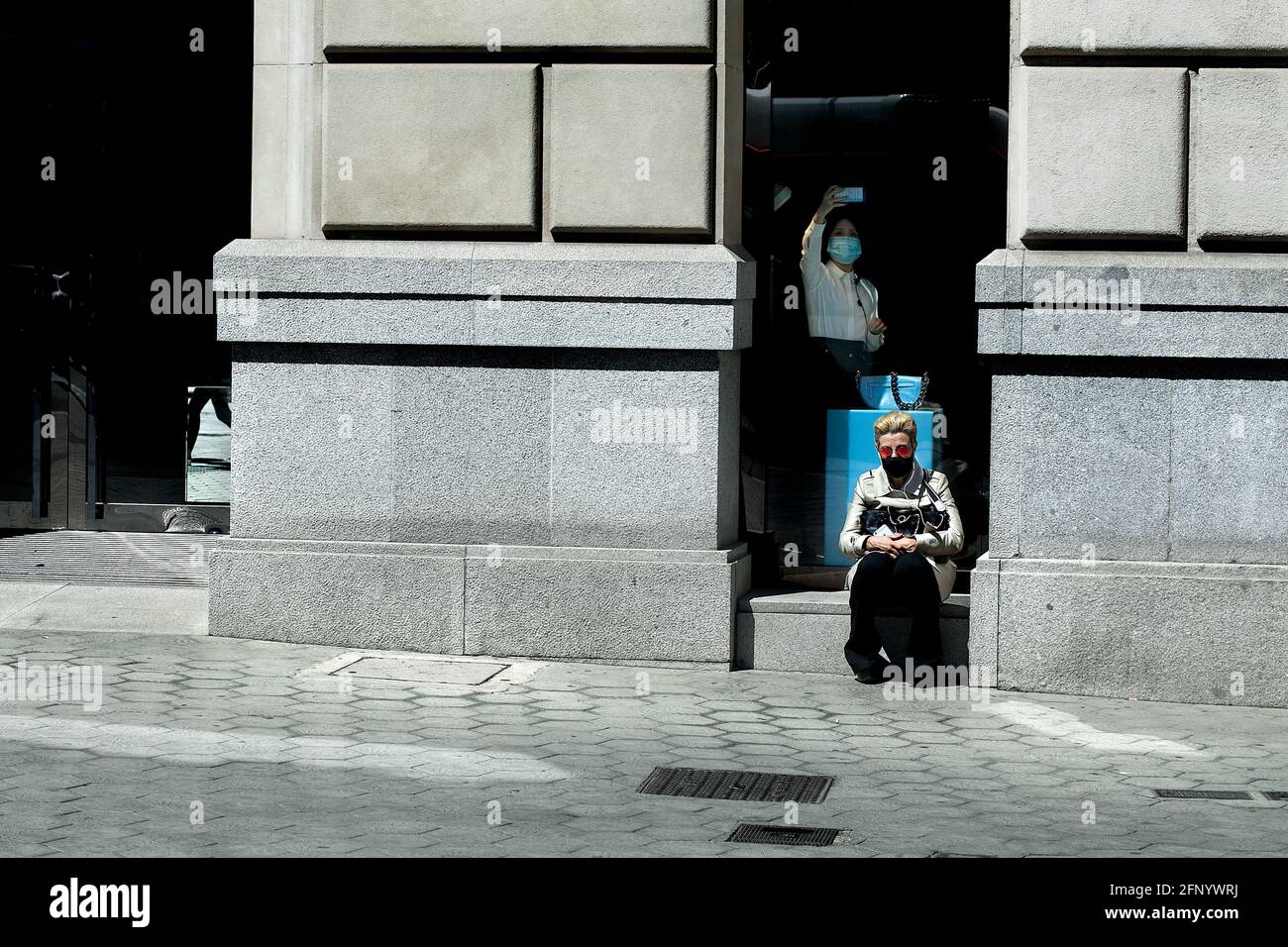 Donna sedette fuori da un negozio, Barcellona, Spagna. Foto Stock