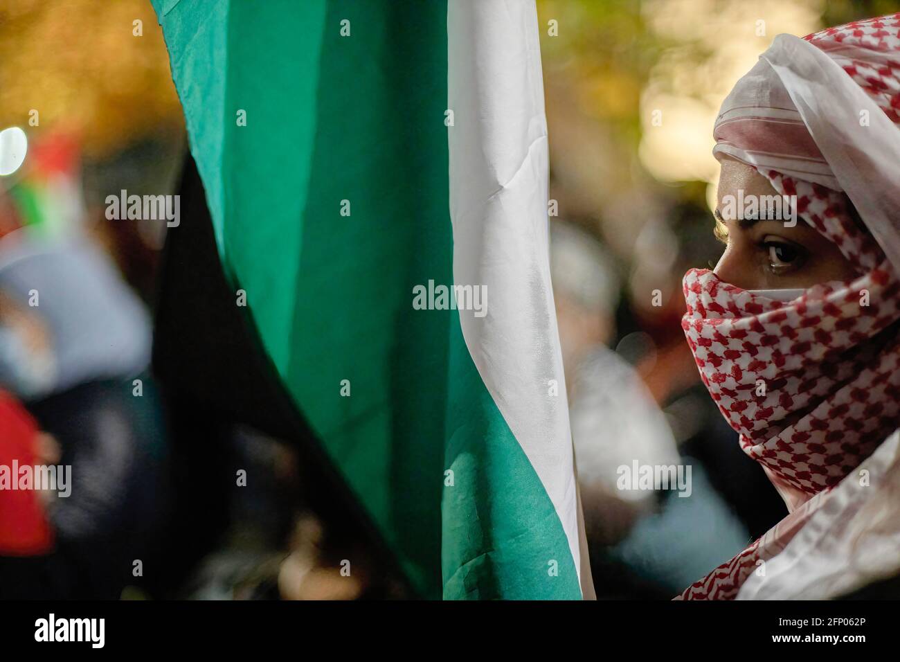 Una bandiera palestinese è vista accanto a una donna che indossa un Keffiyeh durante la protesta. I palestinesi residenti in Cile svolgono un rally pacifico fuori dall'ambasciata israeliana a sostegno del popolo palestinese a seguito della violenza israelo-palestinese recentemente. (Foto di Felipe Figueroa / SOPA Images/Sipa USA) Foto Stock