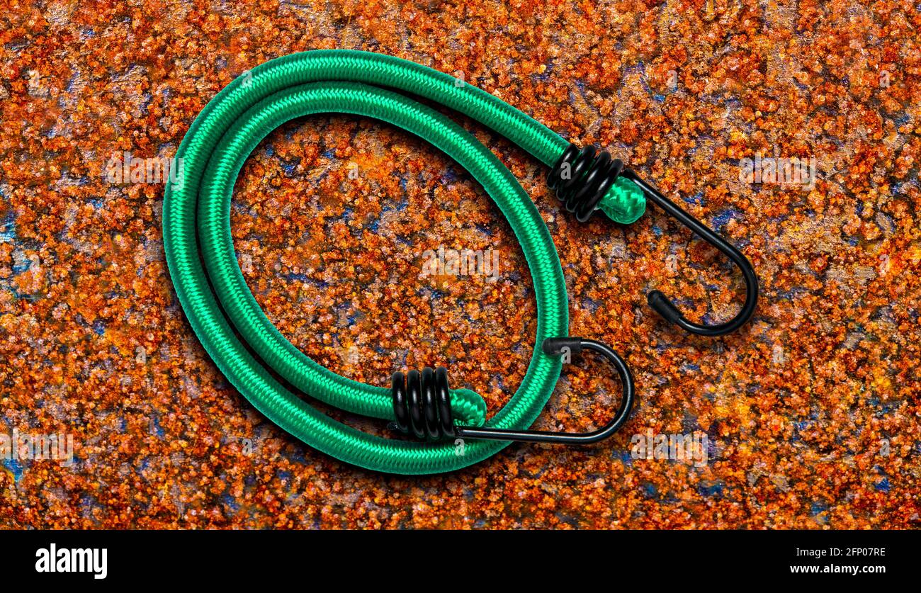 Cordicella per bungee per bagagli su sfondo color ruggine. Foto Stock