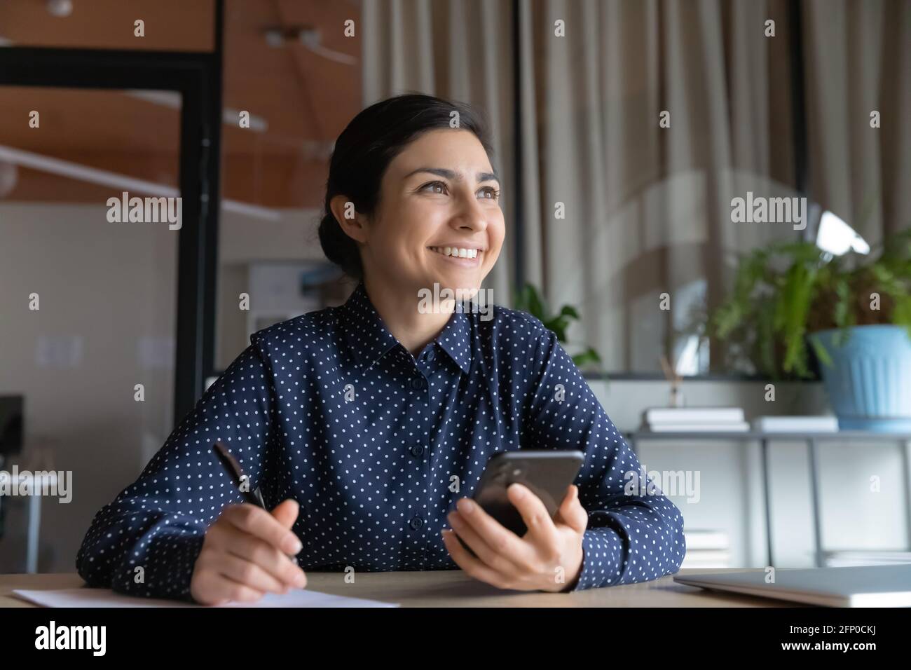 Felice donna indiana lavora con smartphone che fa piani Foto Stock