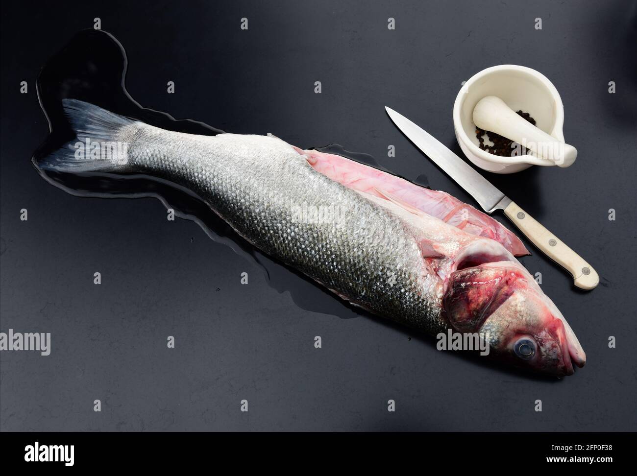 un pesce di spigola selvatico puro pulito e pronto sia condito e cucinato Foto Stock