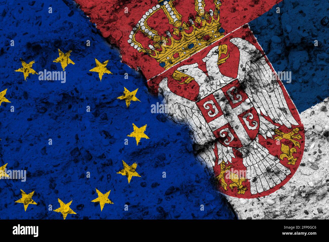 Concetto del rapporto tra l'Unione europea e la Serbia con bandiere dipinte su un muro con una crepa Foto Stock