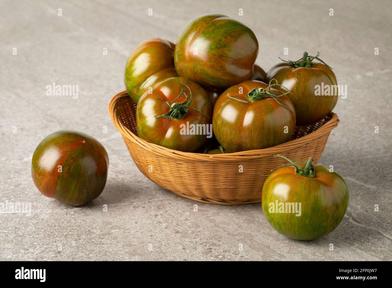 Cestino con pomodori freschi interi a strisce verdi e rossi maturi primo piano Foto Stock