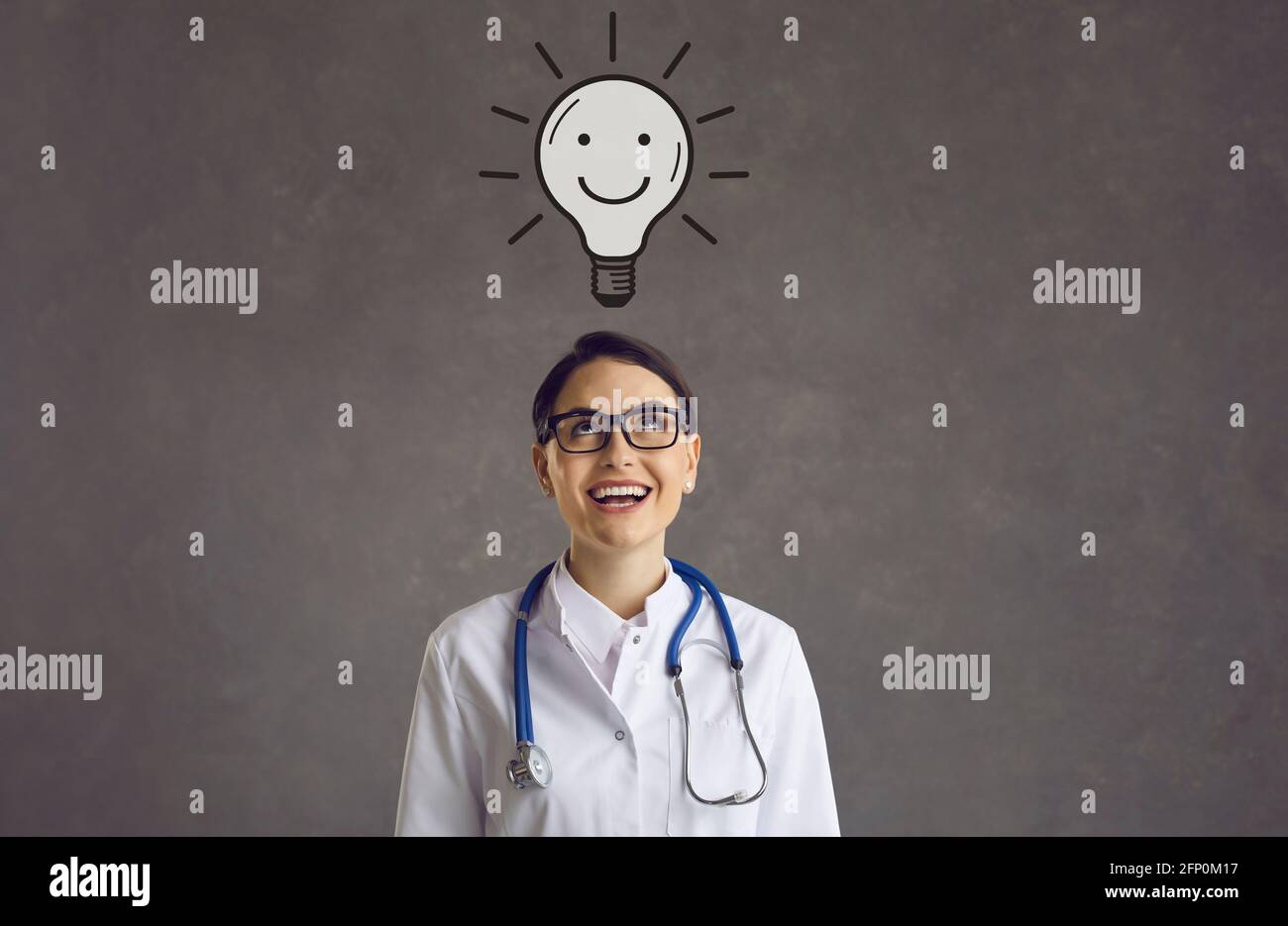 Ritratto di una giovane e felice dottoressa che ha un'idea pensando a qualcosa di divertente. Foto Stock