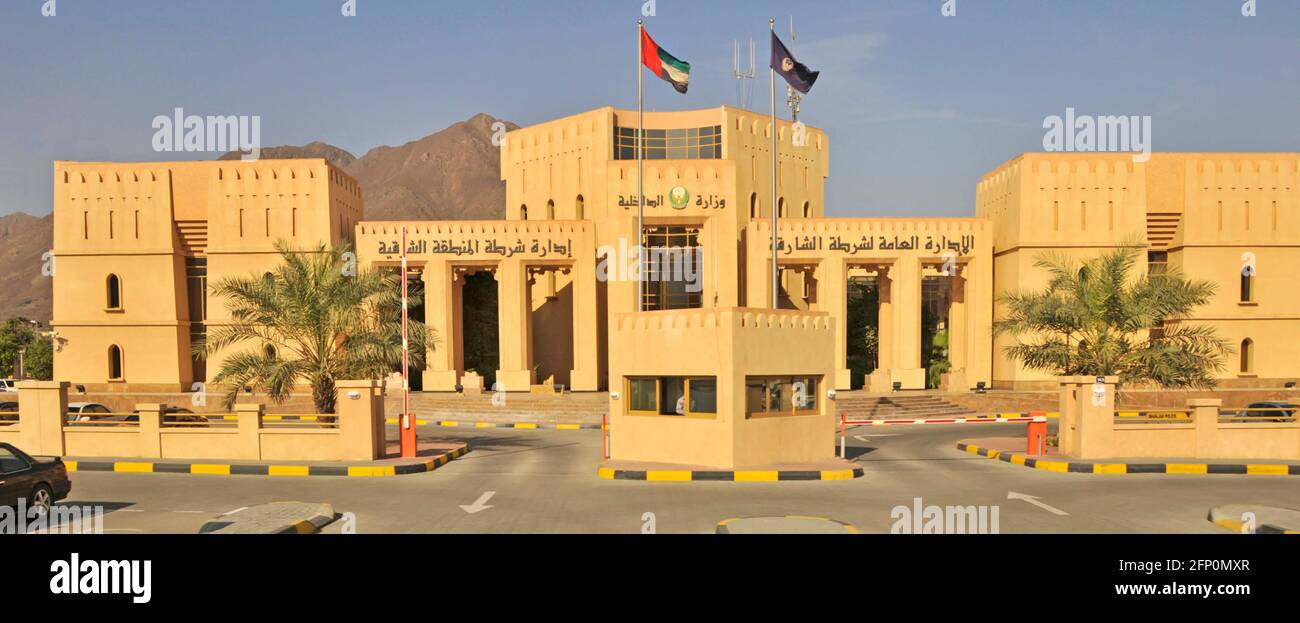 Bandiera degli Emirati Arabi Uniti sopra la façade di Khorfakan o Khor Fakkan Stazione di polizia un edificio governativo nell'Emirato di Sharjah Emirati Arabi Uniti Medio Oriente Foto Stock