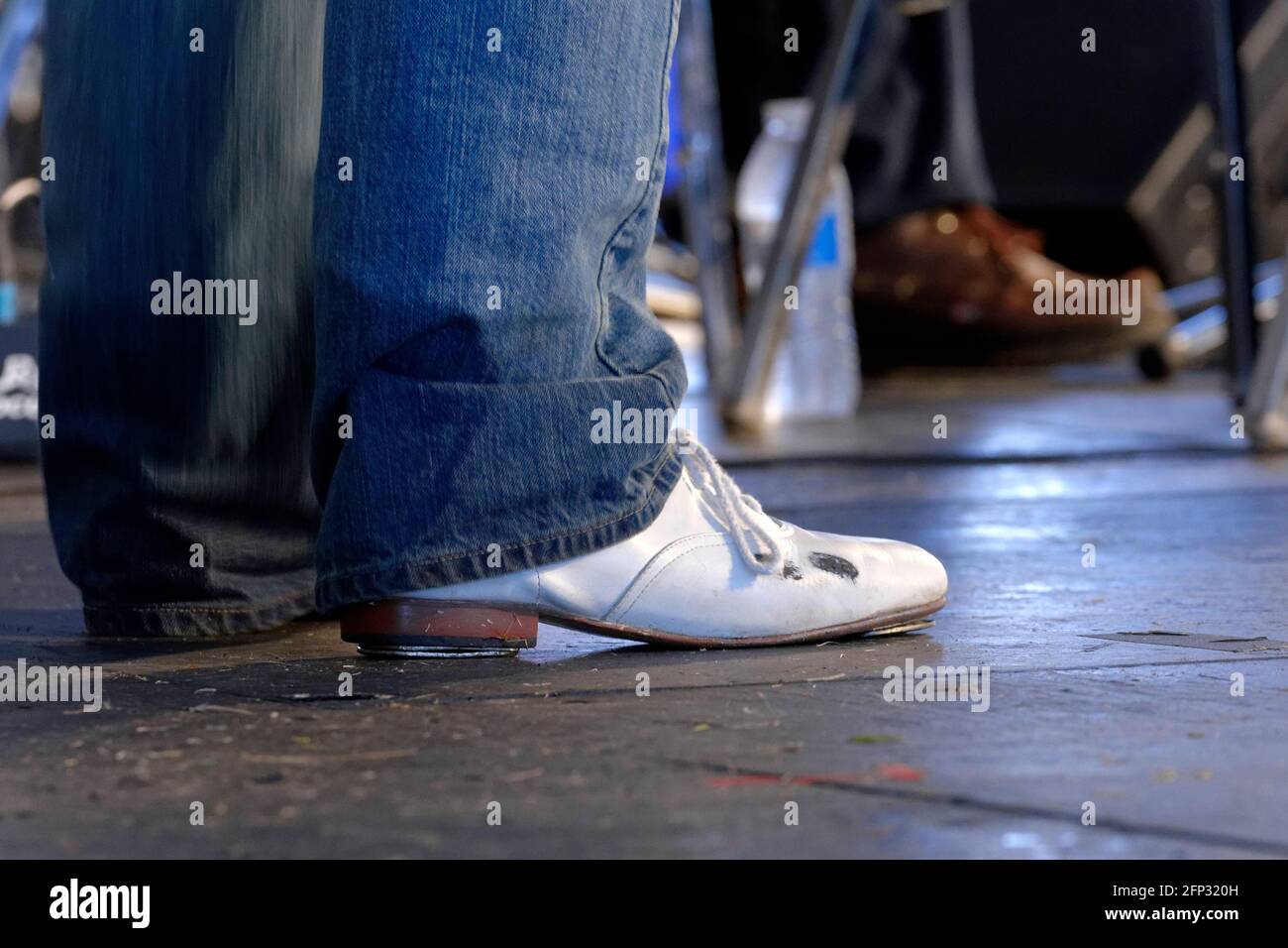 Un ballerino maschile che indossa una scarpa da rubinetto bianca attende la sua esibizione durante un festival folcloristico che propone la danza tradizionale della regione piemontese. Foto Stock