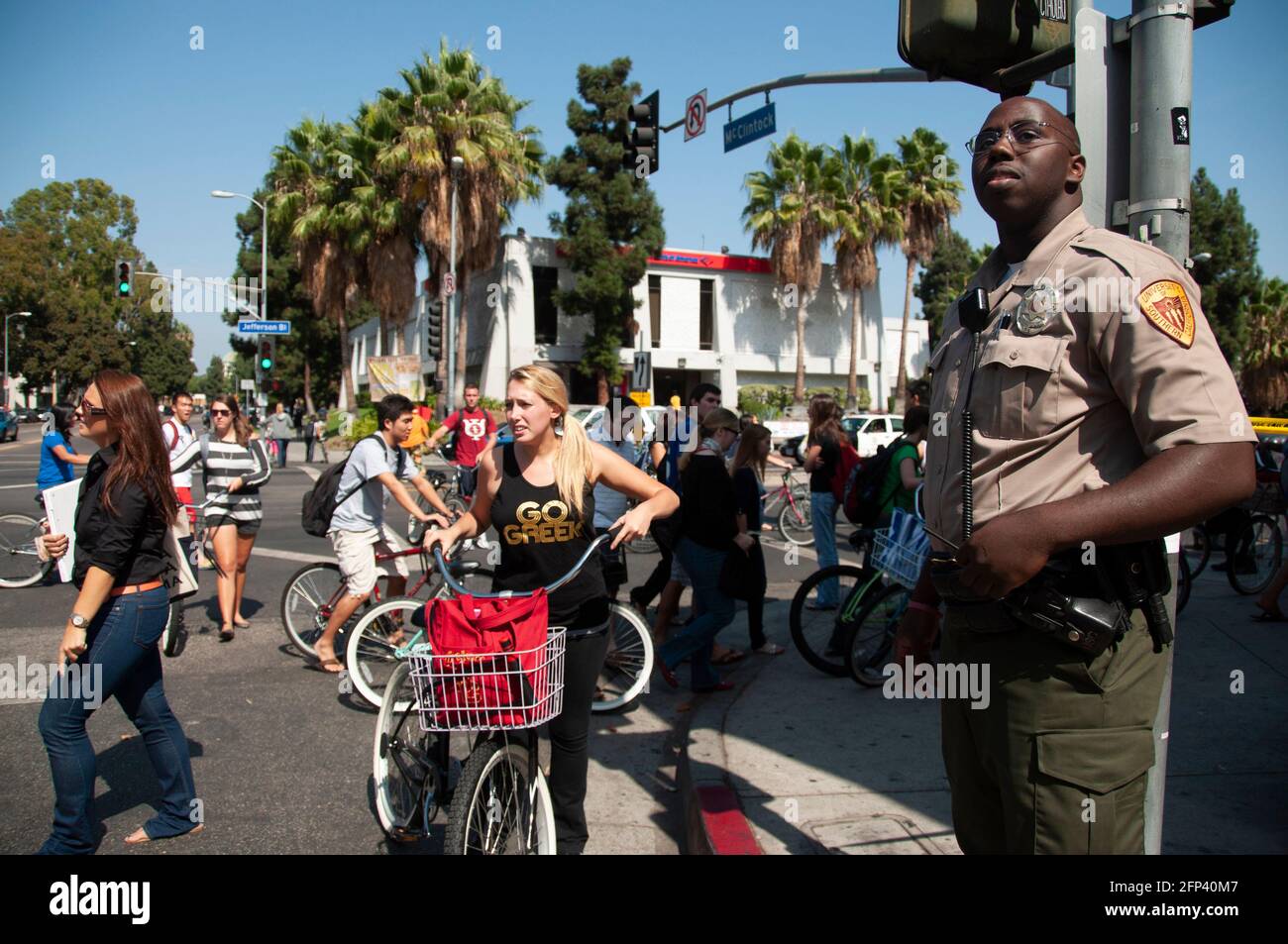Un ufficiale del Dipartimento di pubblica sicurezza della University of Southern California controlla un incrocio mentre gli studenti attraversano la strada. Foto Stock