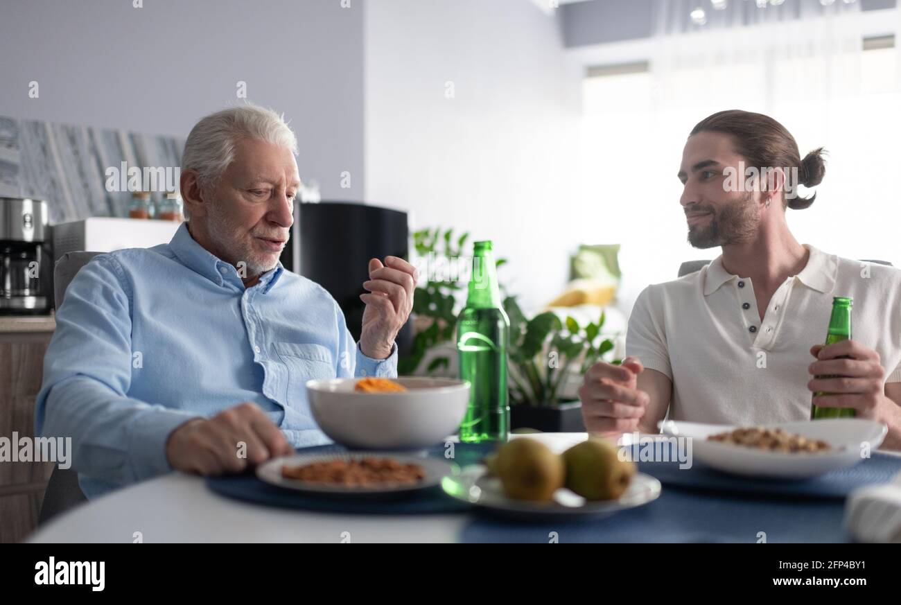 Nonno e nipote che parlano a tavola Foto Stock