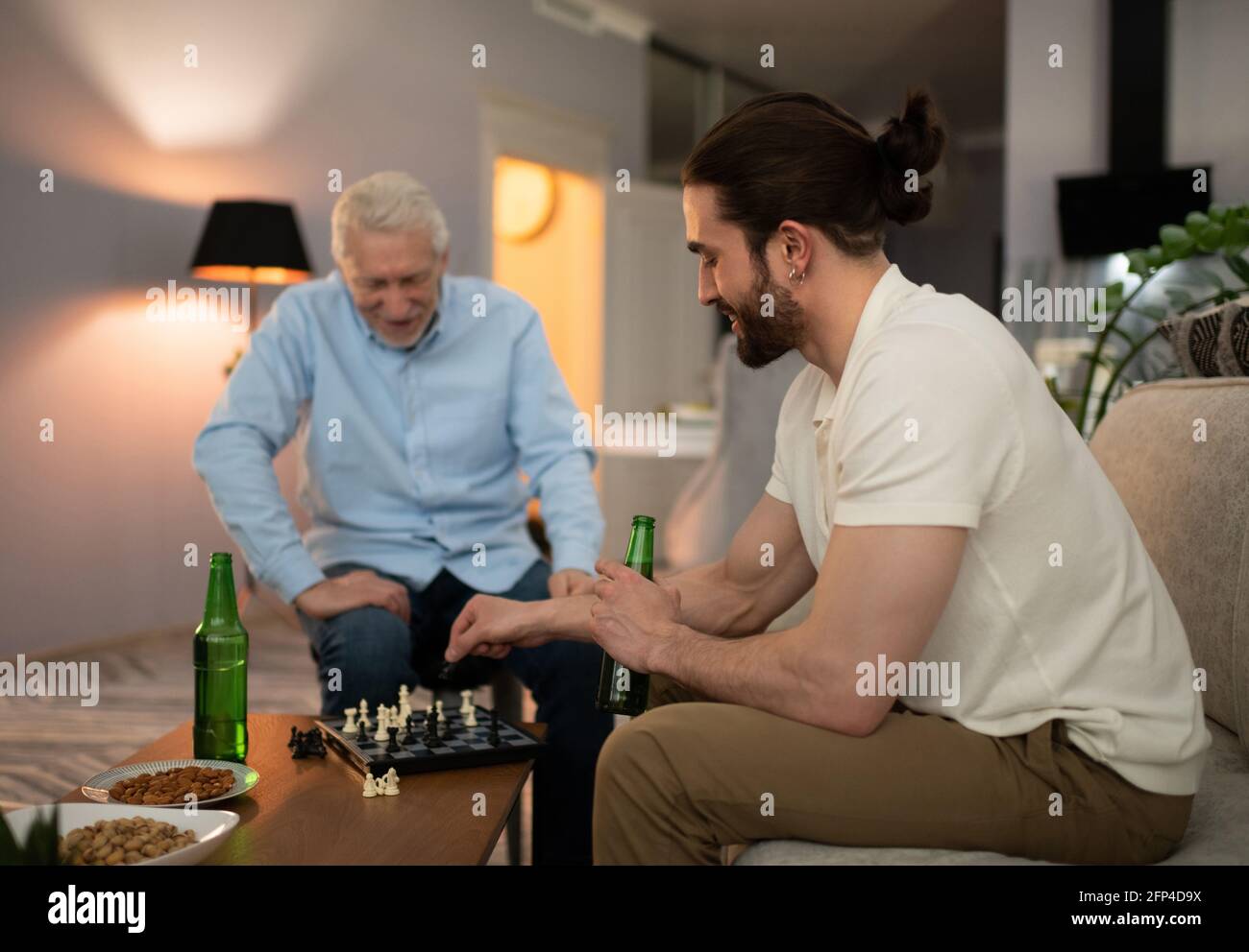 Giovane uomo che gioca a scacchi con nonno Foto Stock