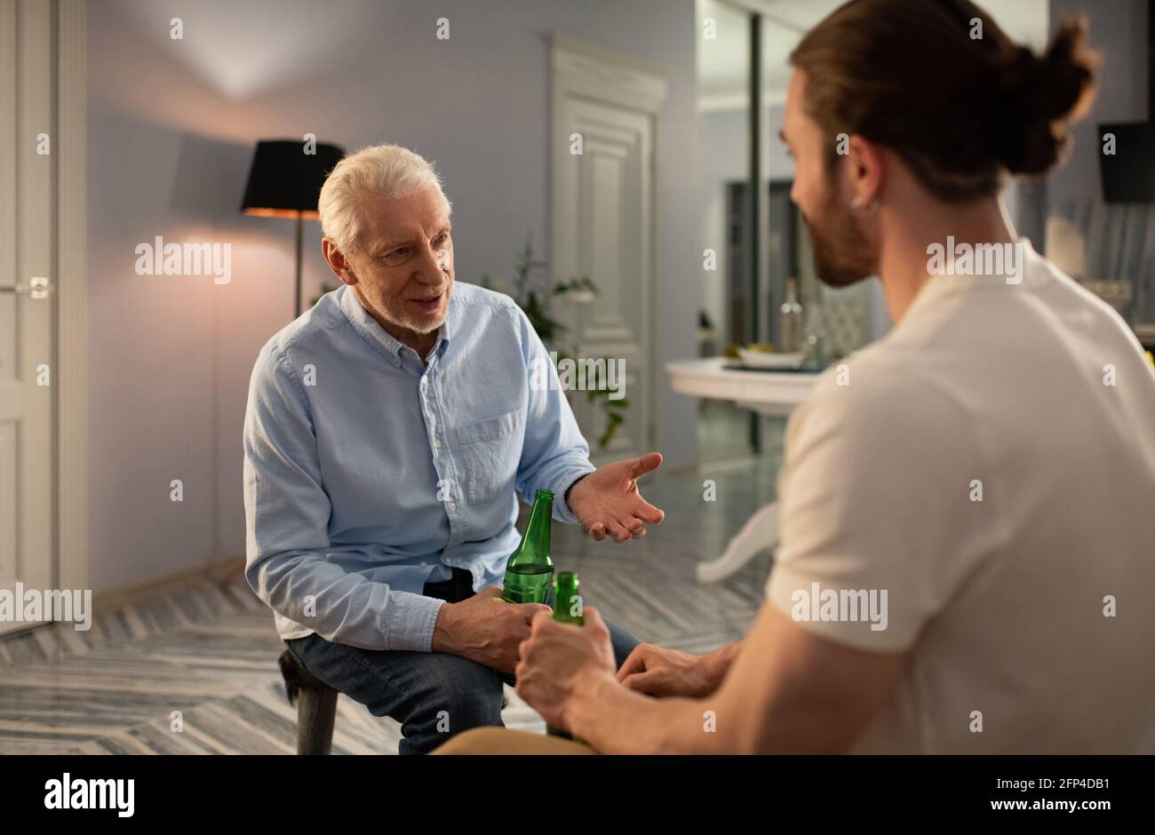 Nonno e nipote bevono birra e chiacchierano Foto Stock