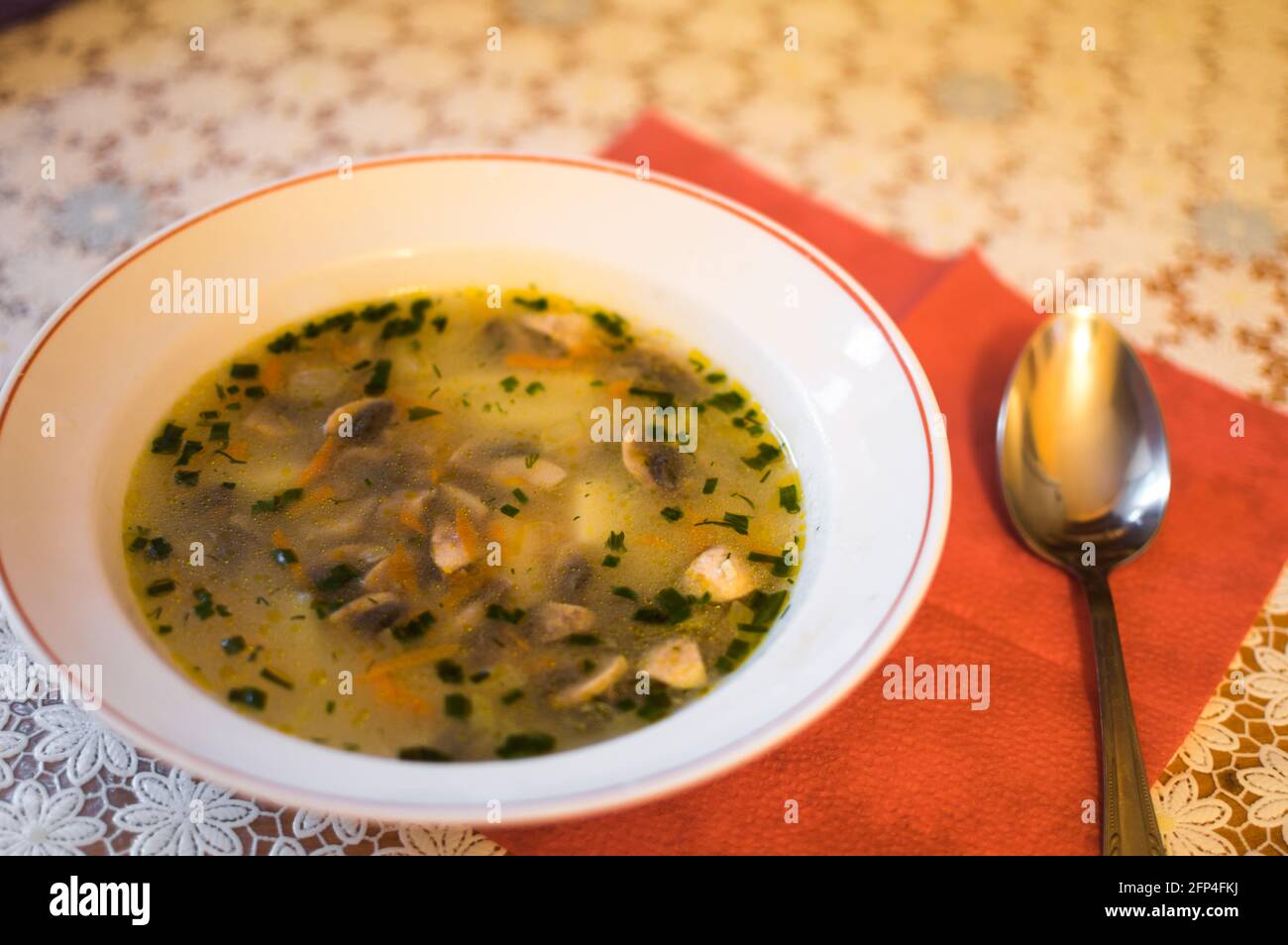Zuppa di funghi fresca in un piatto e un cucchiaio il tavolo Foto Stock