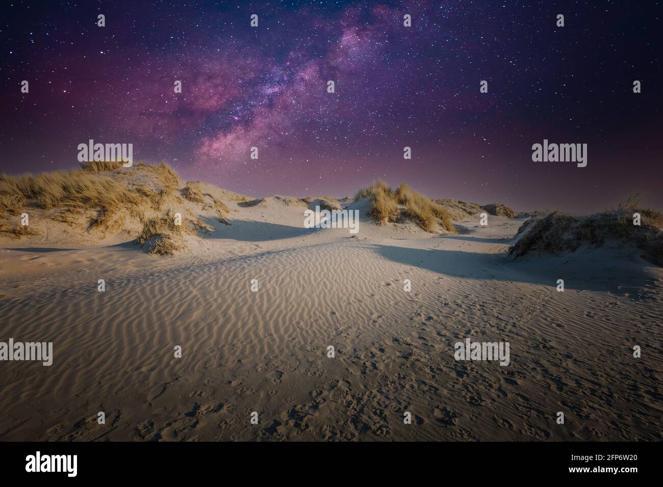 Immagine notturna del paesaggio delle dune con cielo stellato e viola e luce stellare viola su sfondo blu scuro del cielo Foto Stock