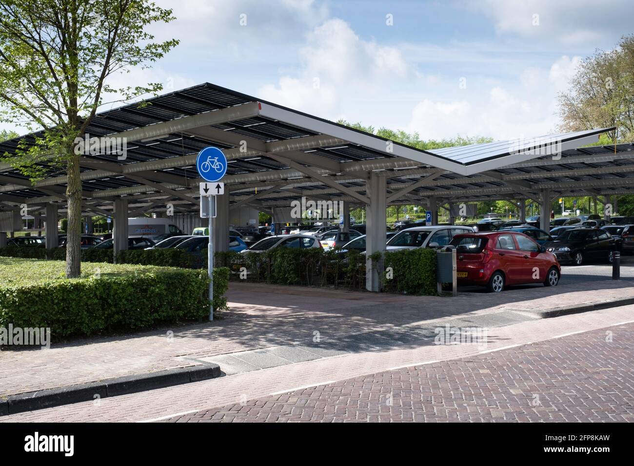 Pannelli solari installati sulla tettoia di un parcheggio auto nel centro della città olandese Dronten. Energia sostenibile e ombra Foto Stock
