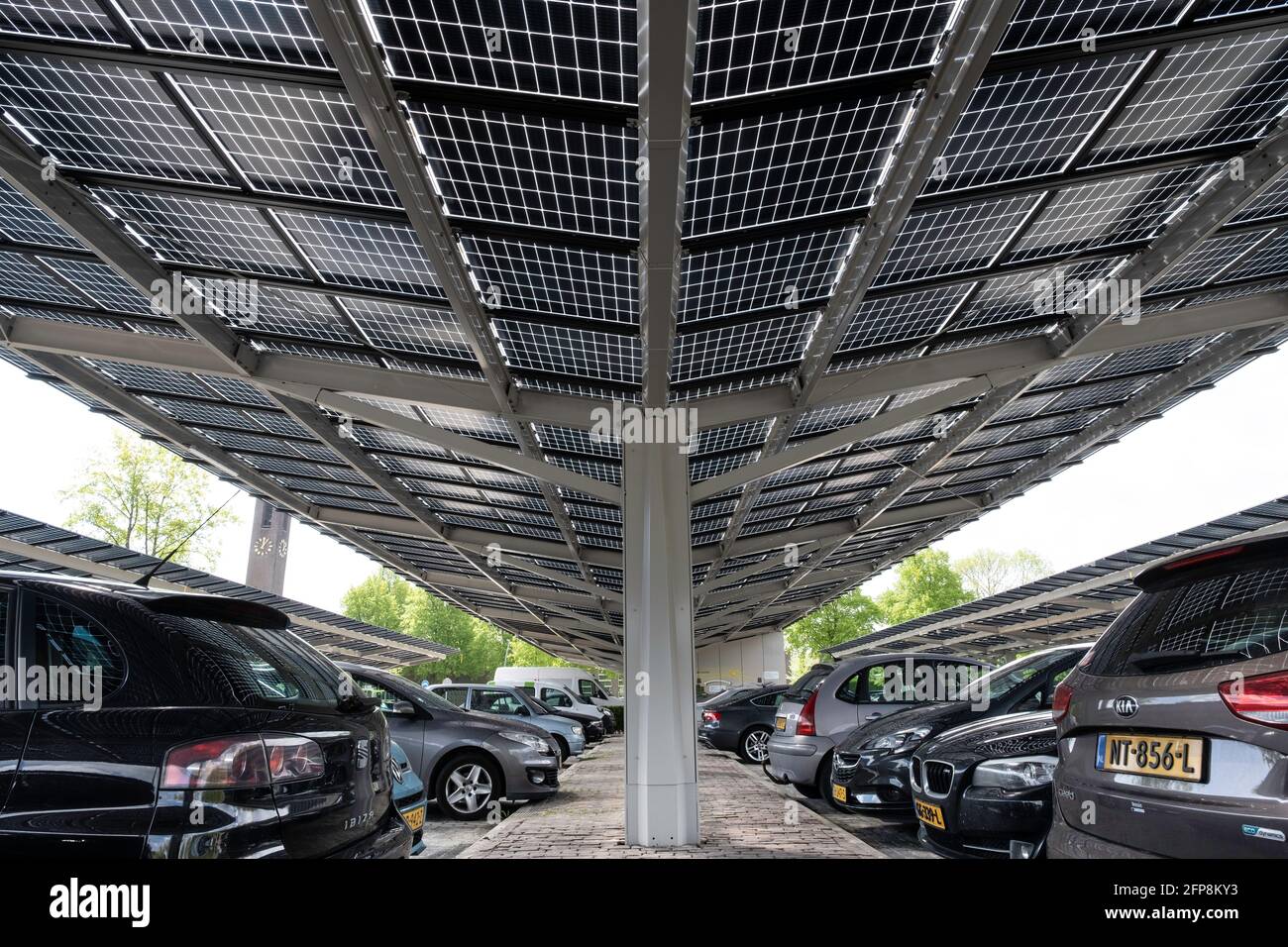 Pannelli solari installati sulla tettoia di un parcheggio auto nel centro della città olandese Dronten. Energia sostenibile e ombra Foto Stock