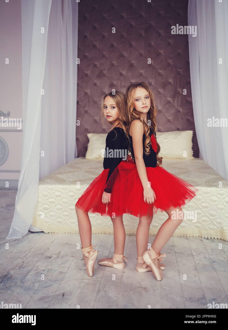 Due bambine in tutu rosso in posa in una stanza. Foto Stock