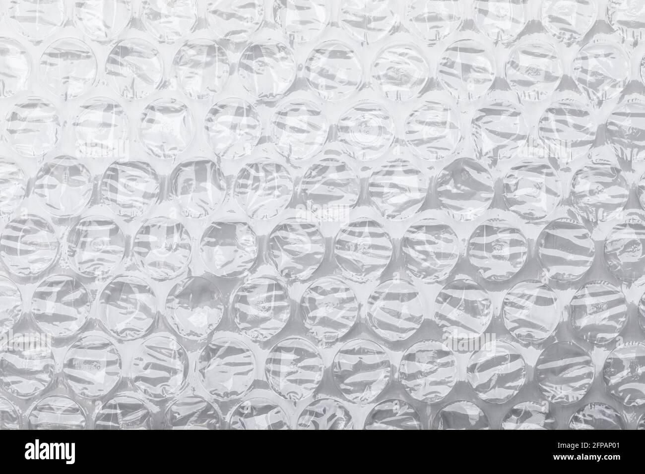 Cuscino d'aria in plastica trasparente pieghevole a bolle d'aria su bianco sfondo Foto Stock