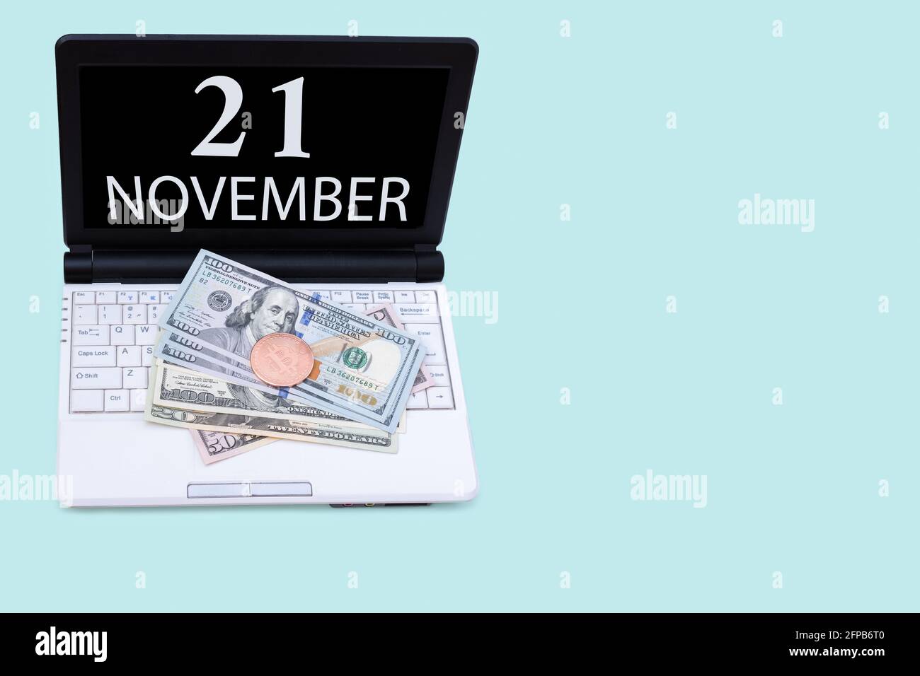21 novembre. Laptop con la data del 21 novembre e criptovaluta Bitcoin, dollari su sfondo blu. Acquistare o vendere Cryptocurrency. Scorte Foto Stock